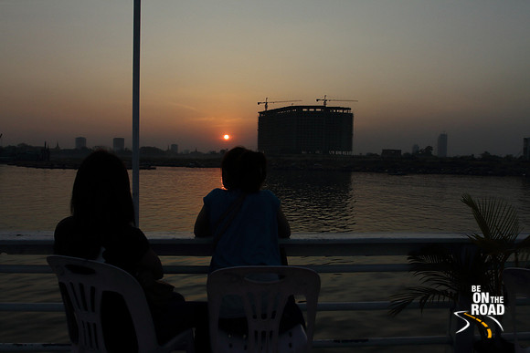 Sun sets by a high rise building by the Mekong river at Phnom Penh