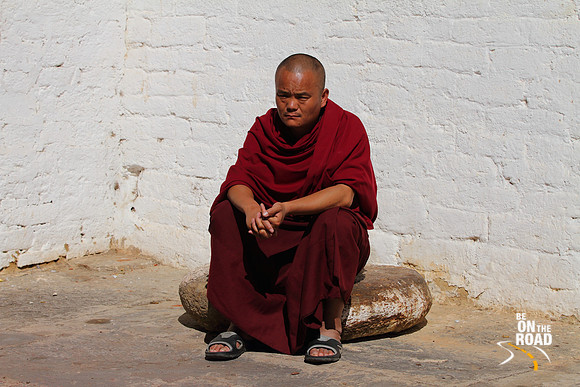 Buddhist monk soaking in the morning sun at Trongsa Dzong, Bhutan