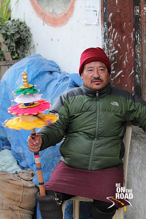 Local Bhutanese Man with a colorful prayer wheel at Trongsa