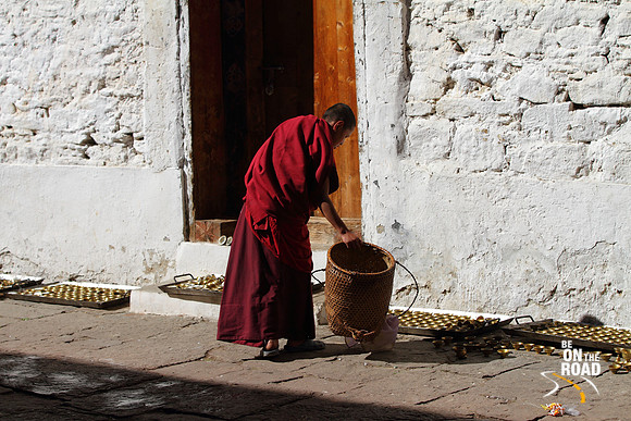 Buddhist Monk cleaning the brass lamps at Trongsa Dzong