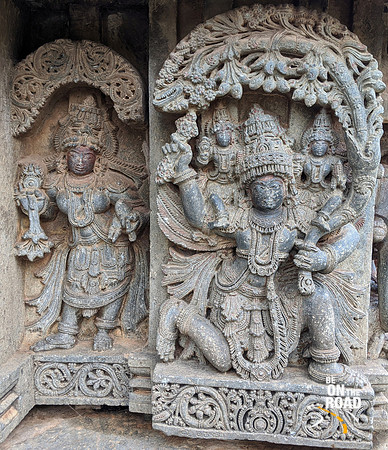 Krishna and Sathyabama borne by Garuda whose left hand holds the Parijata branch - Lakshmi Narasimha Temple, Nuggehalli