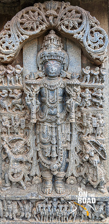 Surya with adoring rishis, accompaniments and guards. A chaya on each side and Aruna driving the 7 horses on the pedestal, Lakshmi Narasimha Temple,Nuggehali