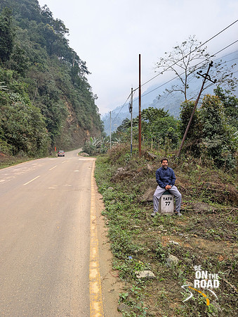 Sreedhar posing on a mile marker enroute Mechuka, Arunachal Pradesh