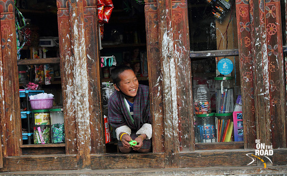 Smiling Bhutanese Kid from a shop window in Trongsa