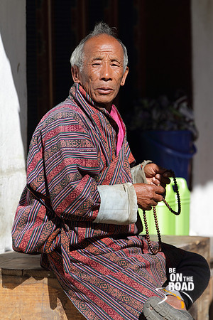 Old Bhutanese man in prayer at Trongsa, Bhutan