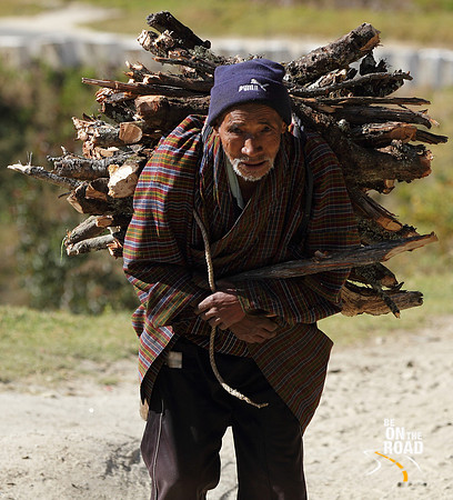 Old man carrying wooden logs at Trongsa, Bhutan