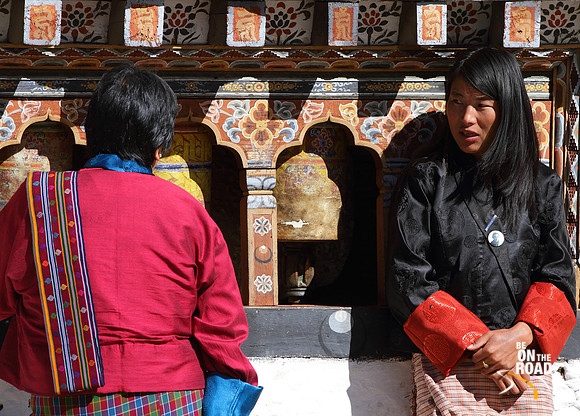 Bhutanese Women in conversation in front of prayer wheels inside Trongsa Dzong, Bhutan